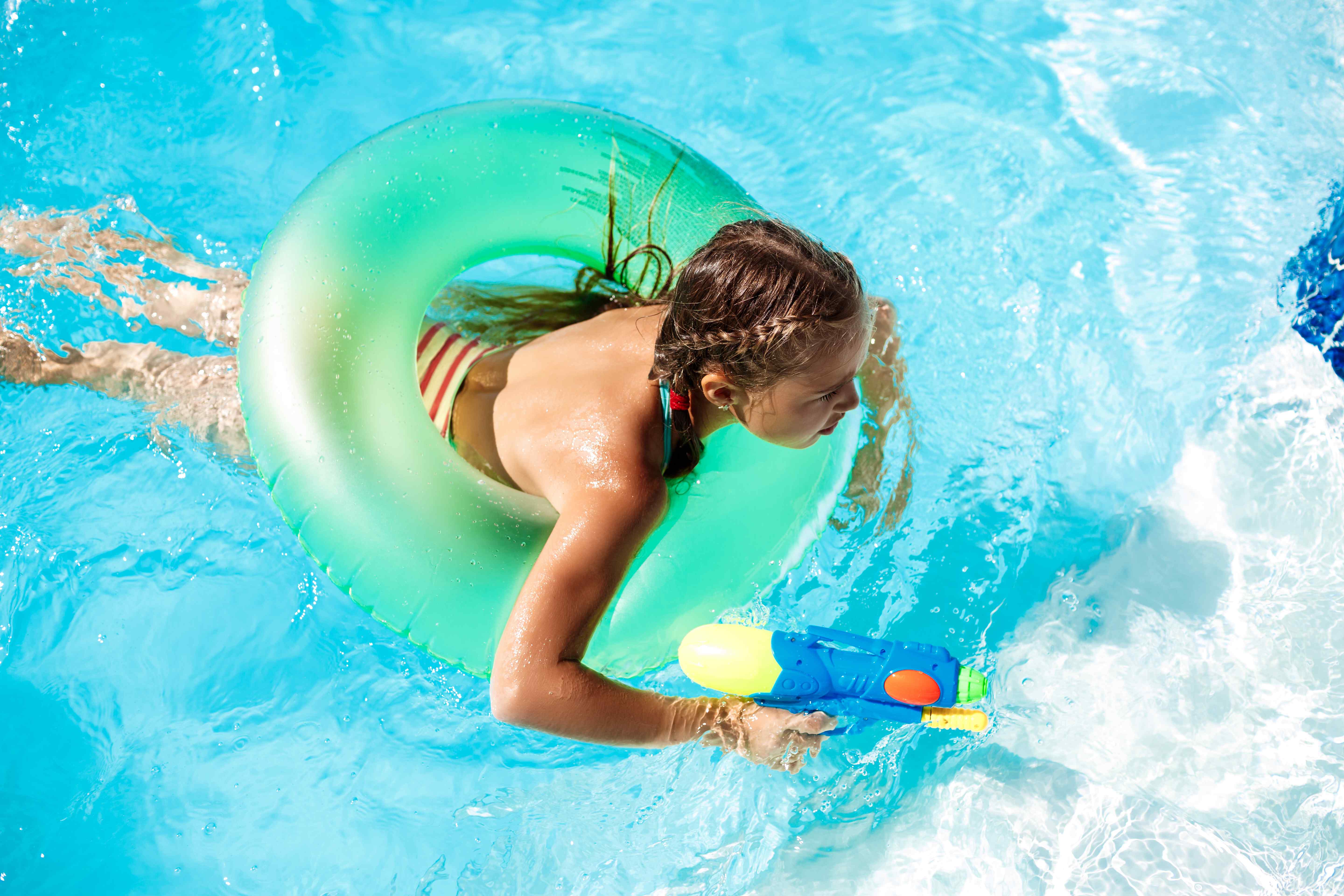 compressed_cheerful-children-playing-waterguns-rejoicing-jumping-swimming-pool